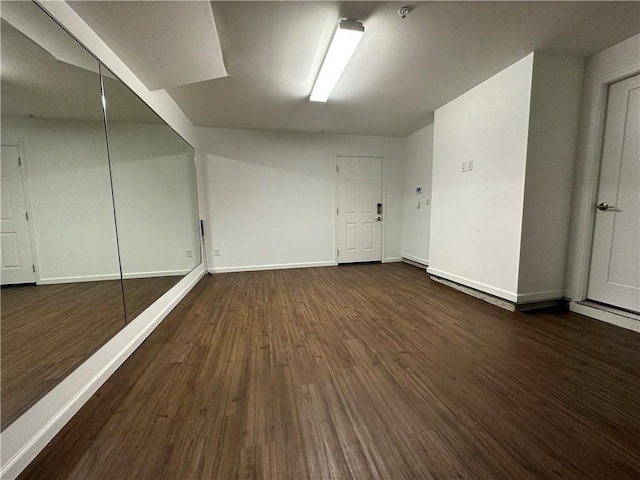 basement with dark hardwood / wood-style floors