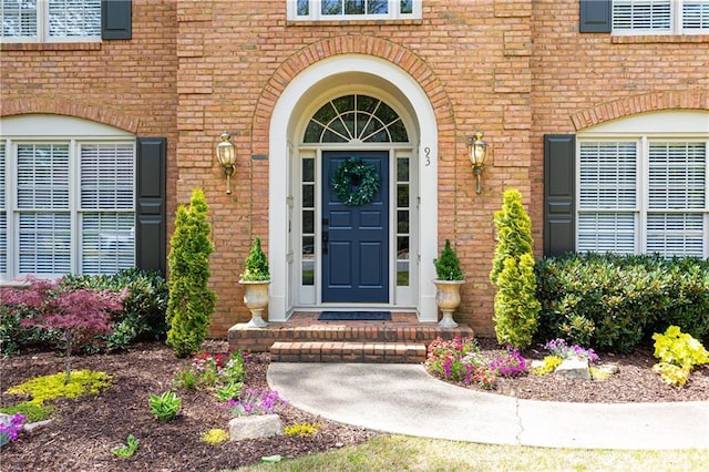 view of exterior entry featuring brick siding