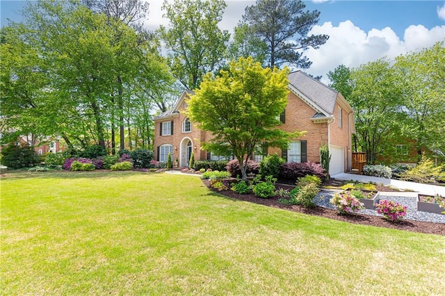georgian-style home with brick siding, a garage, and a front yard