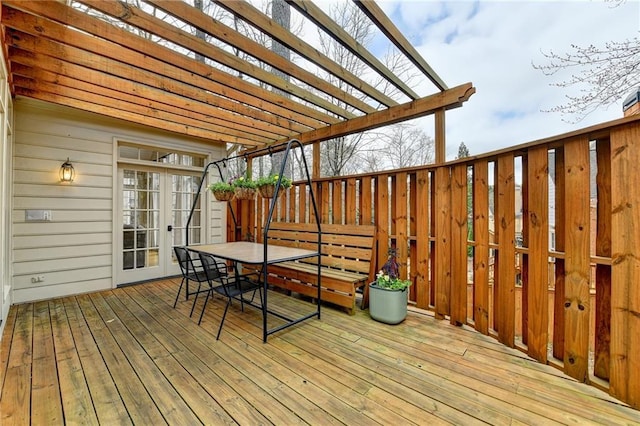 wooden deck featuring a pergola, outdoor dining area, and french doors