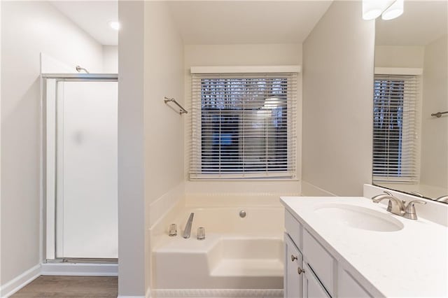 bathroom featuring vanity, hardwood / wood-style floors, and plus walk in shower