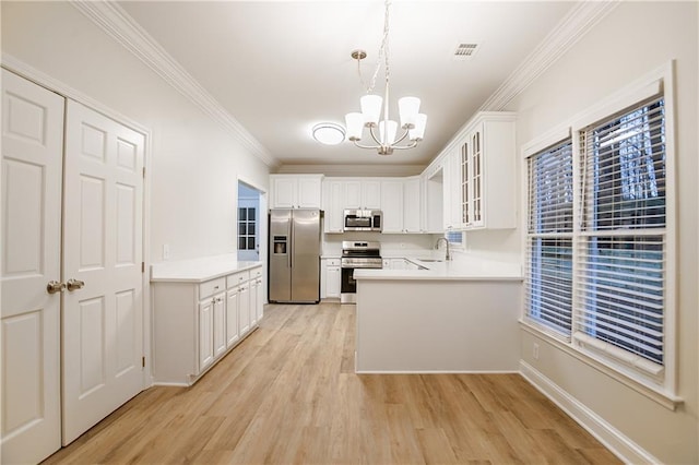 kitchen with white cabinetry, appliances with stainless steel finishes, sink, and hanging light fixtures