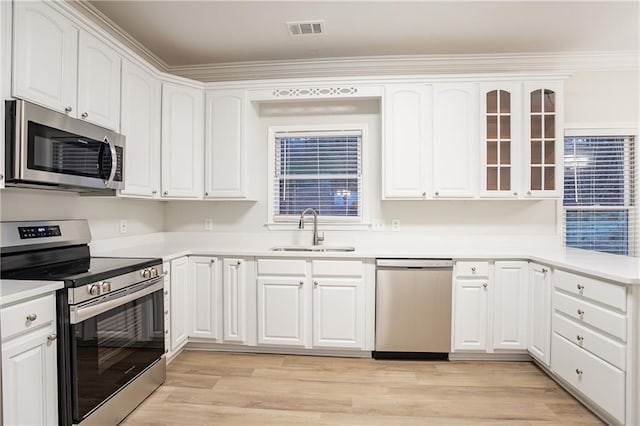 kitchen with stainless steel appliances, sink, and white cabinets