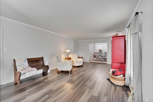 living area with crown molding, hardwood / wood-style flooring, and a textured ceiling