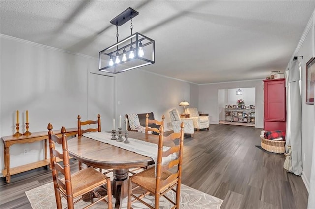 dining area featuring ornamental molding, a textured ceiling, and wood-type flooring