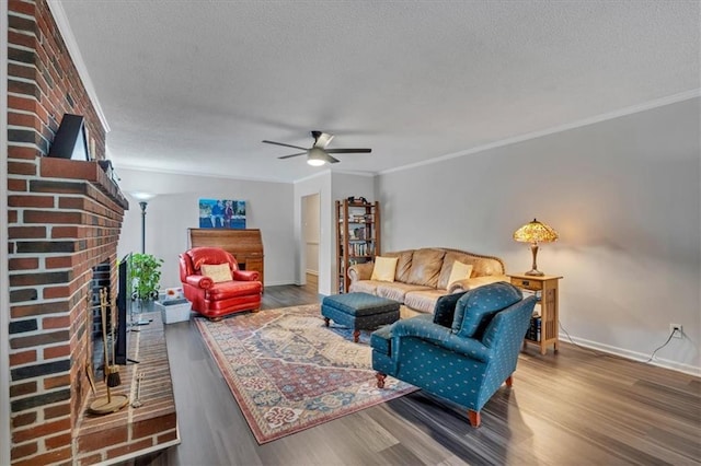 living room featuring ornamental molding, hardwood / wood-style flooring, ceiling fan, and a brick fireplace