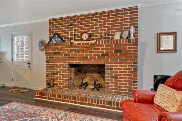 living room featuring ornamental molding, hardwood / wood-style flooring, and a brick fireplace