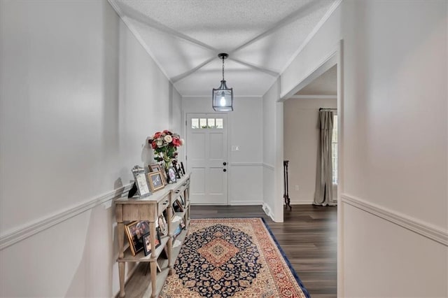 entryway featuring crown molding, a textured ceiling, and dark hardwood / wood-style flooring