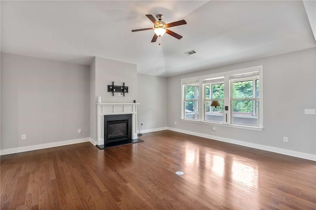1374 Highland Wood Ct, Auburn, GA 30011 - unfurnished living room with ceiling fan, dark wood-type flooring, a glass covered fireplace, baseboards, and lofted ceiling