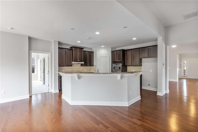 1374 Highland Wood Ct, Auburn, GA 30011 - kitchen featuring oven, dark wood-style flooring, dark brown cabinetry, decorative backsplash, and recessed lighting