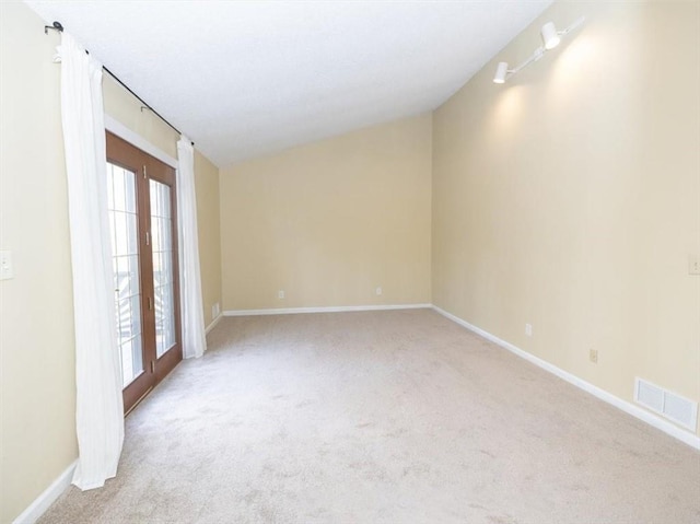 spare room featuring light colored carpet and french doors