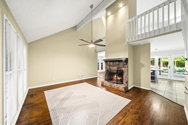 living room with beam ceiling, high vaulted ceiling, dark hardwood / wood-style flooring, ceiling fan, and a fireplace