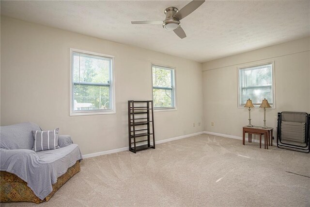 sitting room with light colored carpet and ceiling fan