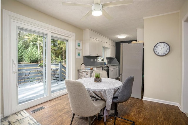 dining space featuring hardwood / wood-style flooring, ceiling fan, a textured ceiling, and sink