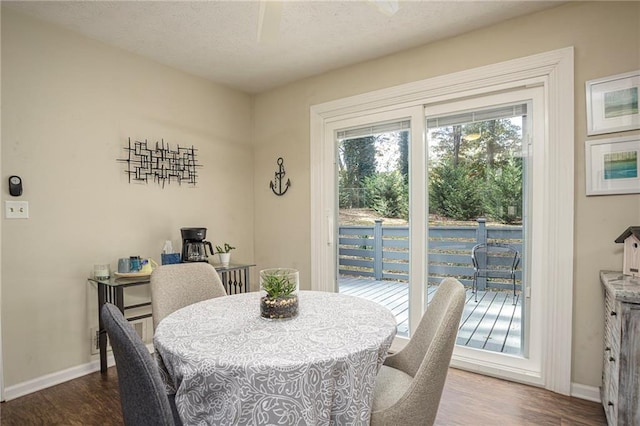 dining space with wood-type flooring and a textured ceiling