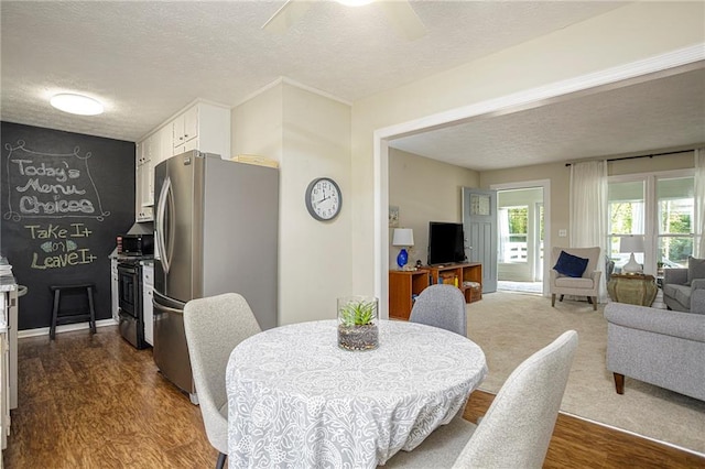 dining space featuring hardwood / wood-style flooring, ceiling fan, and a textured ceiling