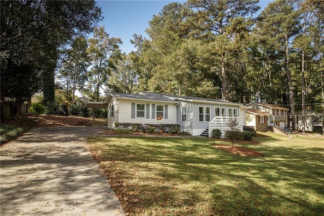 view of front of home with a carport and a front lawn