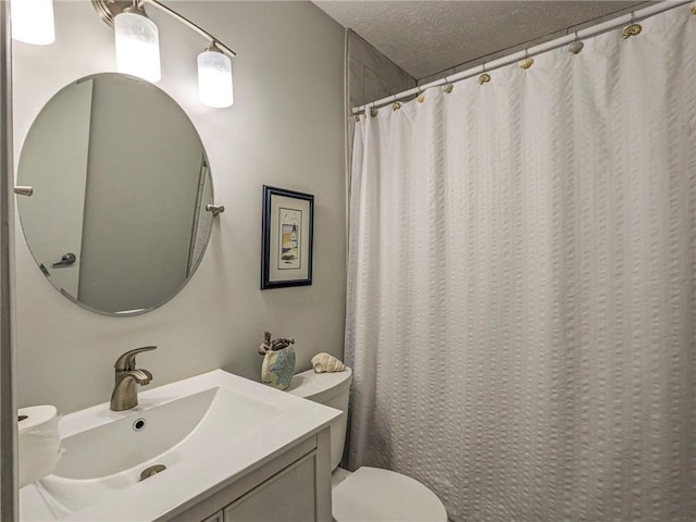 bathroom with vanity, walk in shower, a textured ceiling, and toilet