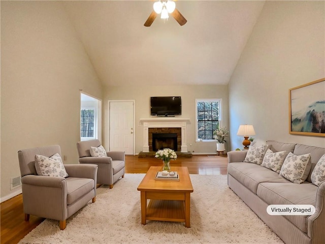 living room featuring hardwood / wood-style floors, high vaulted ceiling, and ceiling fan