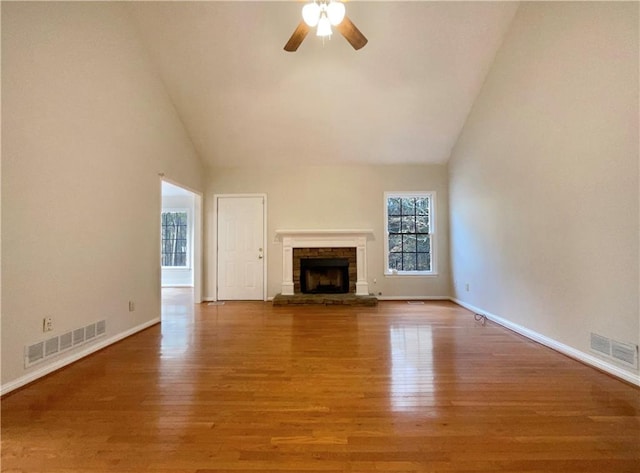 unfurnished living room with hardwood / wood-style flooring, ceiling fan, high vaulted ceiling, and a fireplace