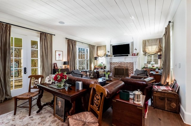 living room with plenty of natural light, hardwood / wood-style floors, and a brick fireplace