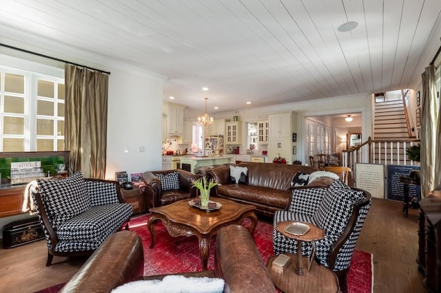 living room featuring wood-type flooring, wood ceiling, a chandelier, and crown molding