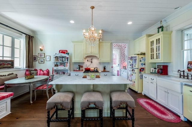 kitchen with a notable chandelier, white appliances, a center island, sink, and dark wood-type flooring