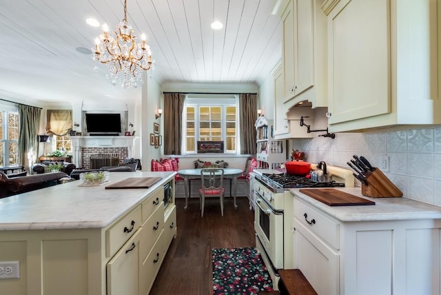 kitchen featuring backsplash, a fireplace, an inviting chandelier, high end range, and dark hardwood / wood-style floors