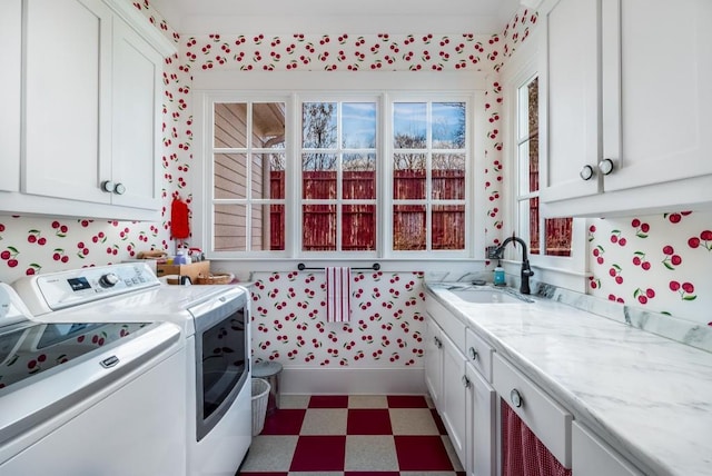 interior space with white cabinets, plenty of natural light, washer and dryer, and sink