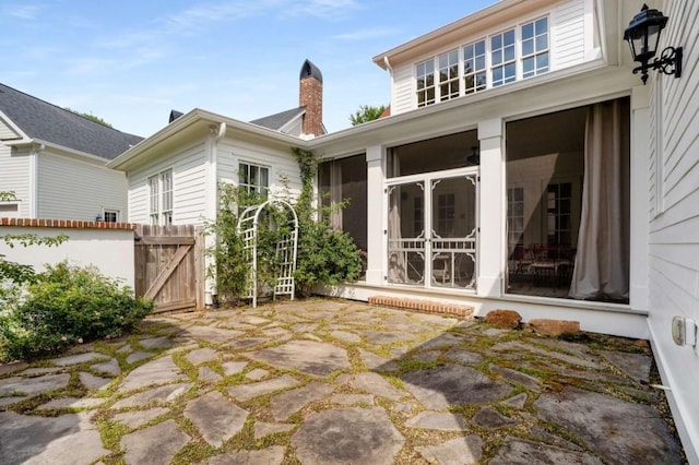 rear view of property with a sunroom and a patio