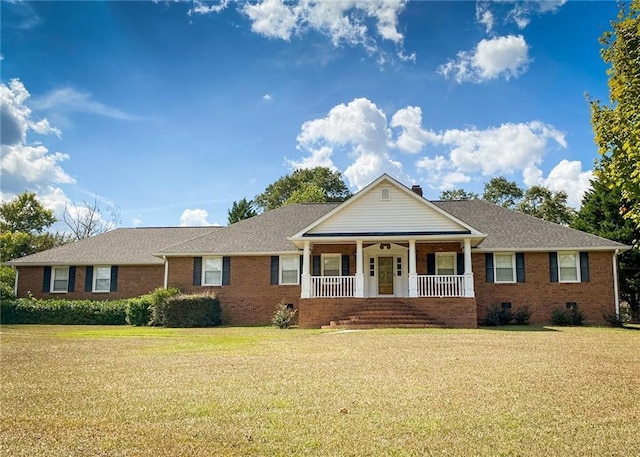 ranch-style home featuring covered porch and a front yard