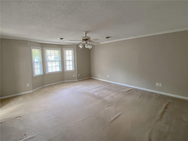 spare room with a textured ceiling, ceiling fan, ornamental molding, and light carpet