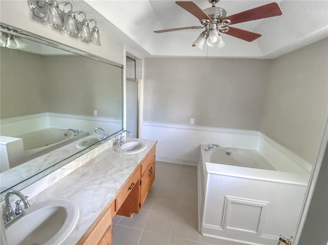 bathroom with tile patterned flooring, vanity, ceiling fan, and a bath