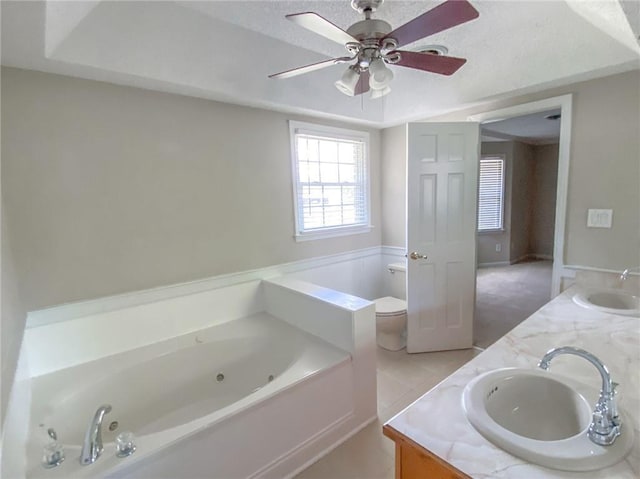 bathroom with vanity, tile patterned flooring, ceiling fan, a washtub, and toilet