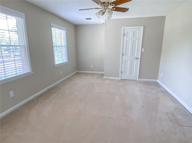 carpeted empty room with ceiling fan and a textured ceiling