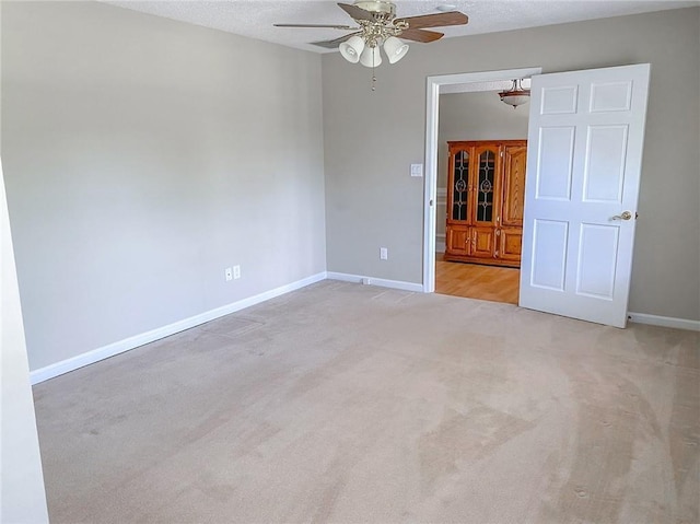 carpeted empty room with ceiling fan and a textured ceiling