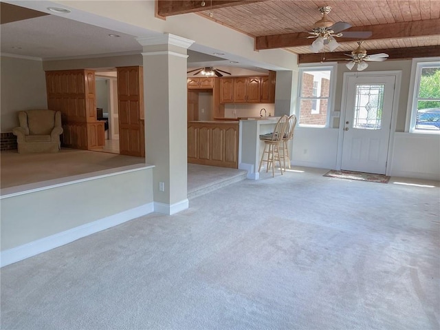 unfurnished living room featuring beam ceiling, light colored carpet, crown molding, and wooden ceiling