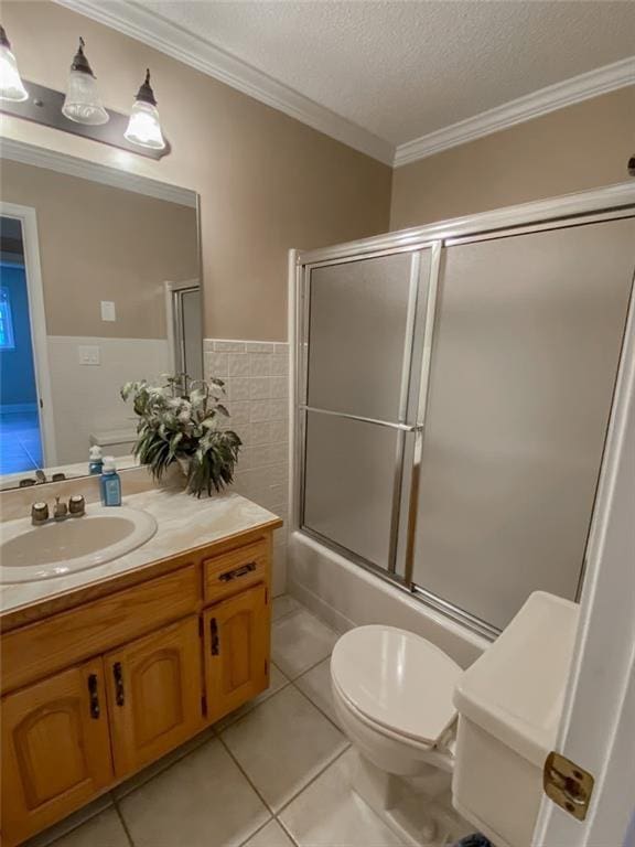 full bathroom featuring vanity, tile patterned floors, crown molding, toilet, and a textured ceiling