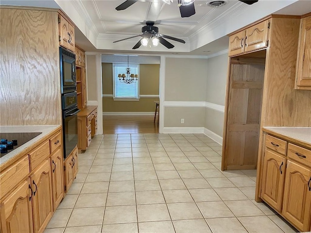 kitchen featuring light tile patterned floors, a raised ceiling, crown molding, and black appliances