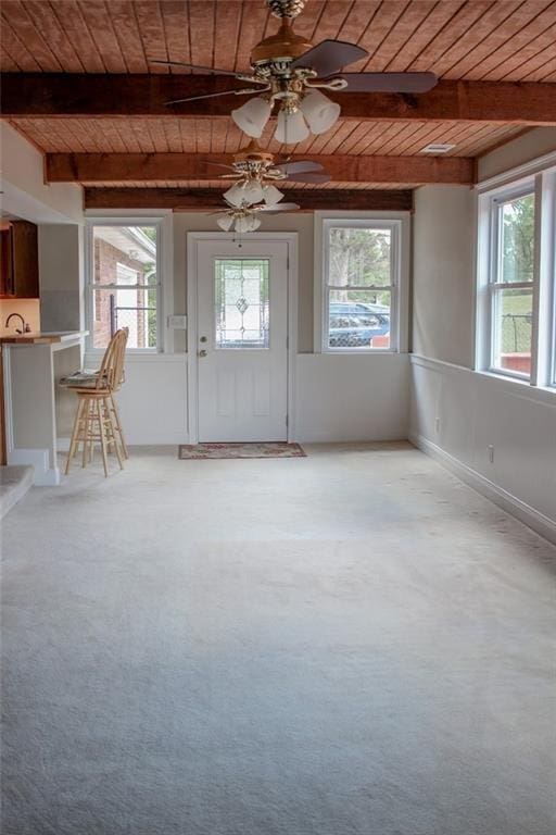 interior space featuring carpet, beam ceiling, and wood ceiling