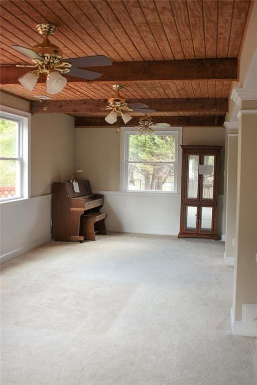 spare room with ceiling fan, beam ceiling, light colored carpet, and wooden ceiling