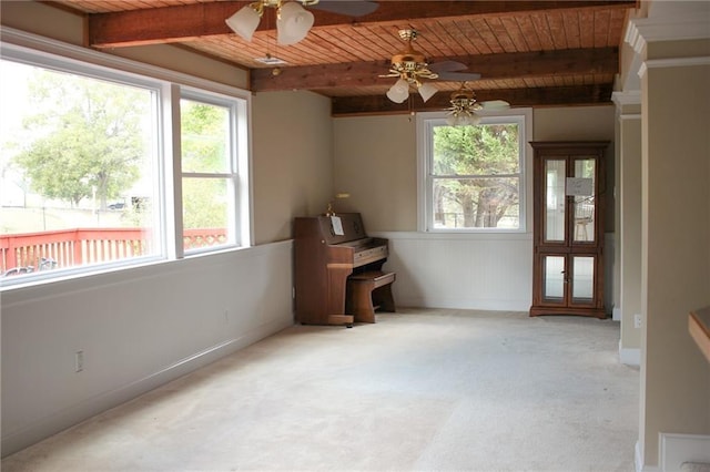 unfurnished room featuring beam ceiling, light colored carpet, wooden ceiling, and a wealth of natural light