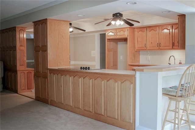 kitchen with light carpet, a kitchen breakfast bar, sink, crown molding, and kitchen peninsula