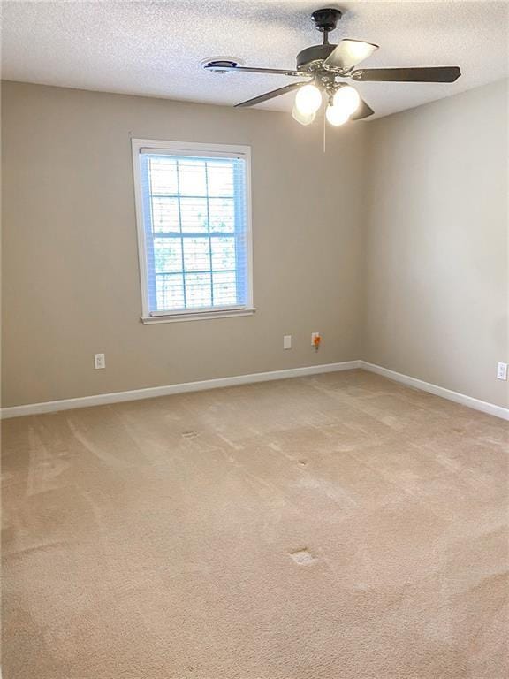 unfurnished room with light carpet, ceiling fan, and a textured ceiling