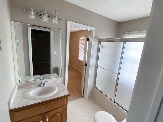 full bathroom featuring vanity, toilet, and bath / shower combo with glass door