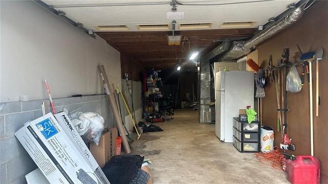 garage with a garage door opener and white refrigerator