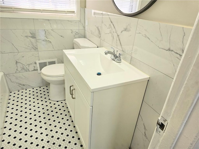 bathroom featuring tile walls, tile patterned floors, vanity, and toilet