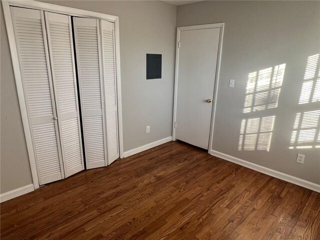 unfurnished bedroom with a closet and dark hardwood / wood-style flooring