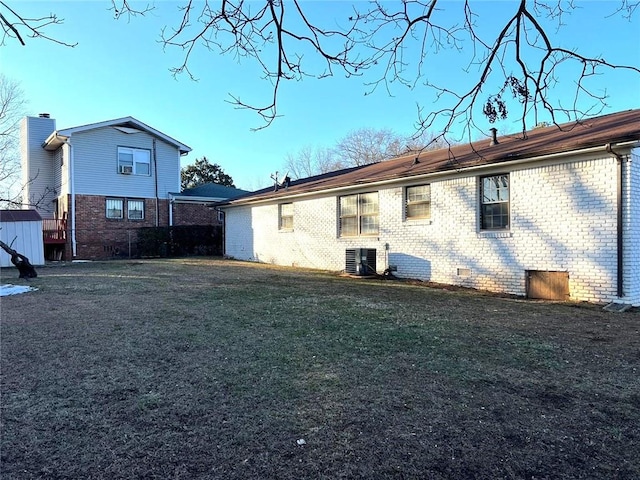 rear view of property with a yard and central air condition unit