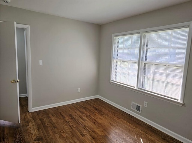 unfurnished room with dark wood-type flooring